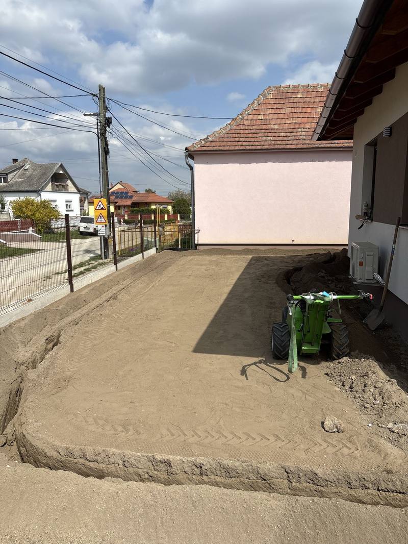 Machine grading and soil spreading during garden construction, with a compact loader